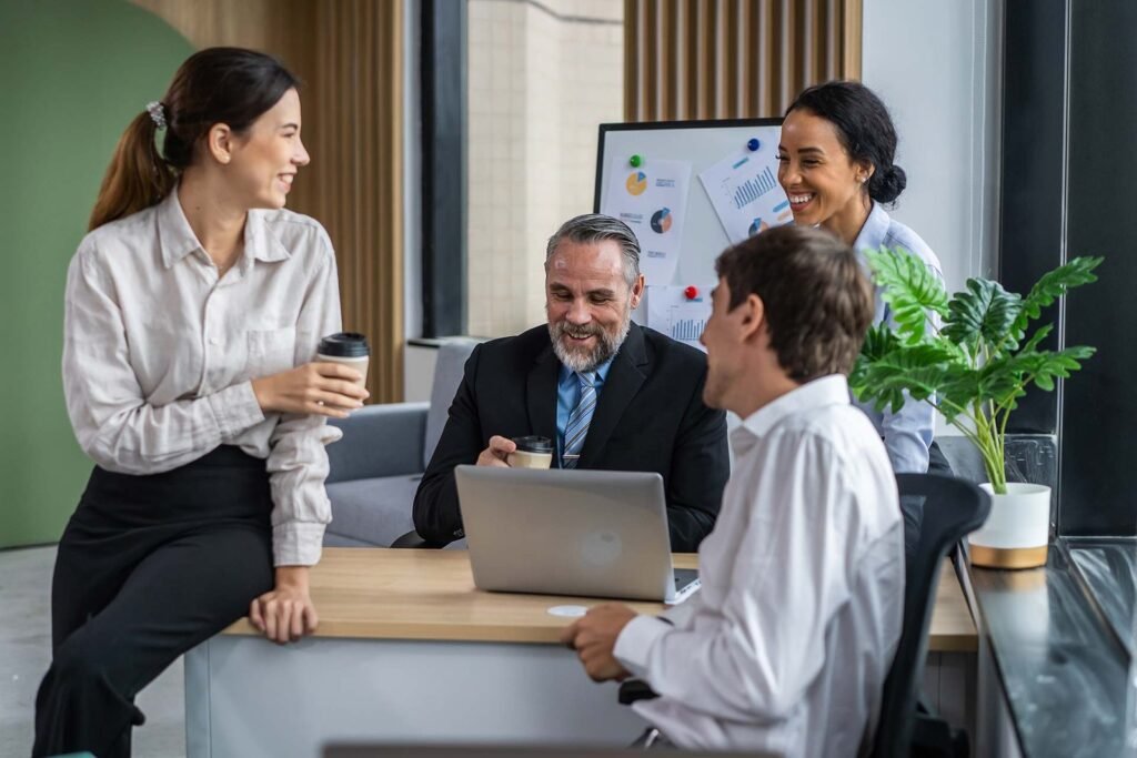 Grupo de empleados de oficina sonriendo y tomando café